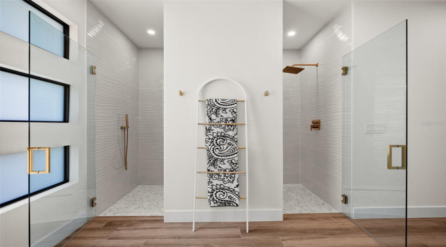 Primary Bathroom With Dual Roman Showers With Frameless Glass.