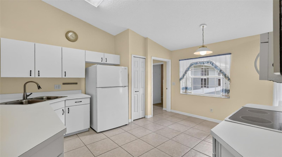 Kitchen With White Cabinetry And Appliances.