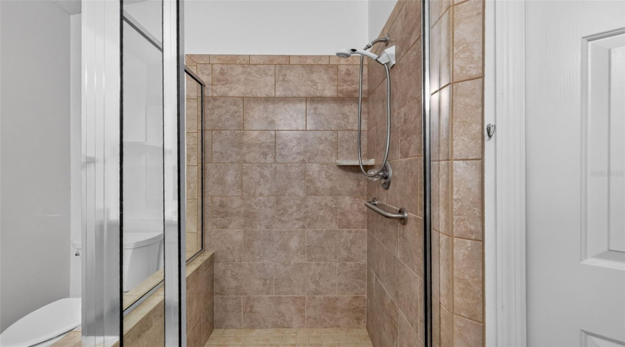 Primary Suite Bathroom With Tiled Shower.