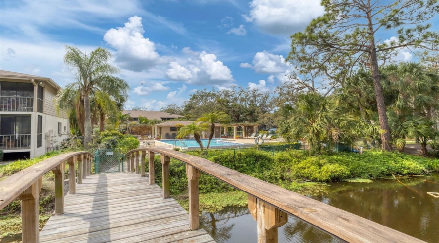 Wooden Footbridge To Pool Area With Pergola, Kitchen And Baths