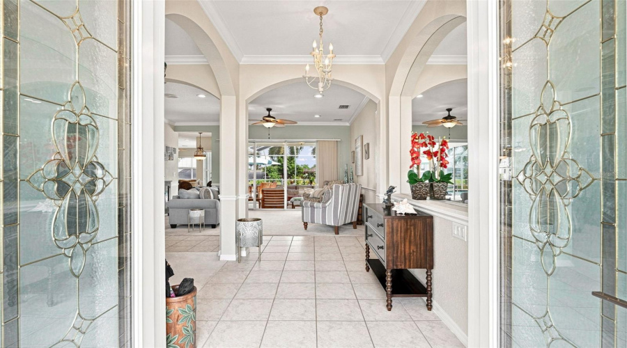 Elegant Foyer With Arched Details &Amp; Leaded Glass Double Doors