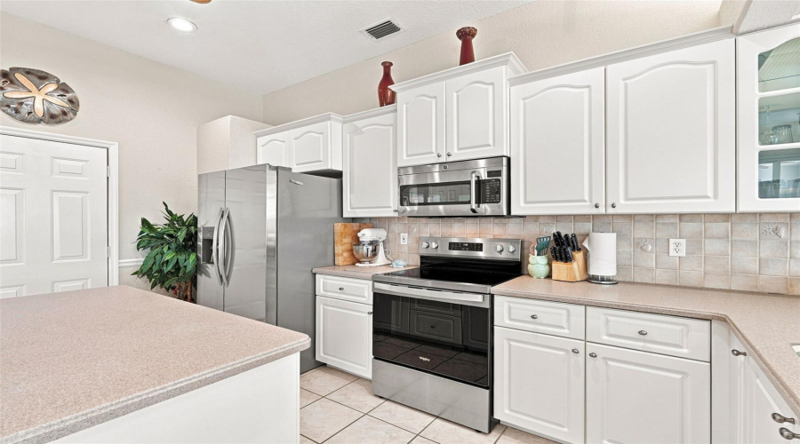 Stainless Appliances &Amp; Staggered Cabinetry With Showcase Door