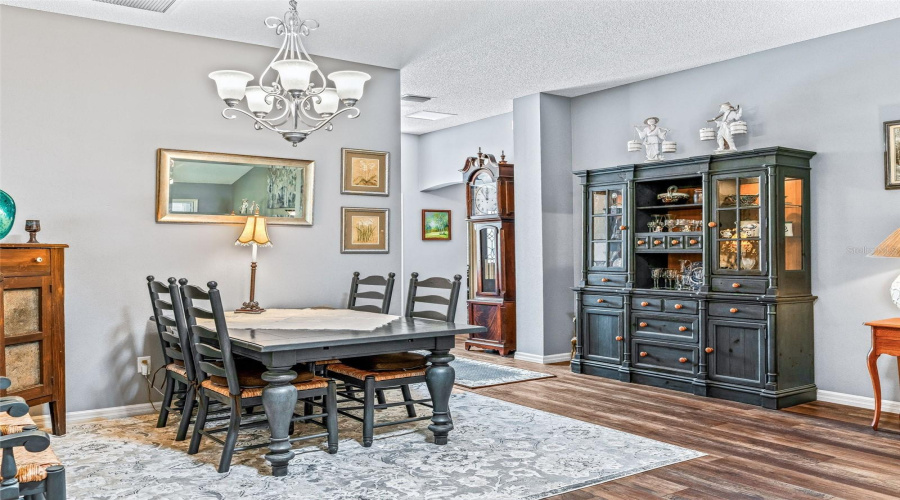 Comfortable Dining Space Features An Attractive Chandelier, Wood-Look Flooring, And Room For A Large Table, China Cabinet, Or Serving Pieces.