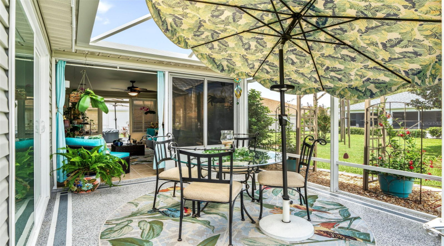 Another Angle Of The Charming Patio Beneath A Decorative Canopy Umbrella Offers A Comfortable Setting For Outdoor Dining, Morning Coffee, Or Casual Entertaining. Birdcage Is Roofed With Clear Florida Plexiglass For A Dry Environment!