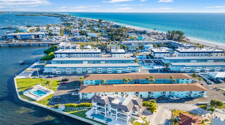 Aerial Perspective Of Waterfront Community With Pool, Parking, And Bay Frontage