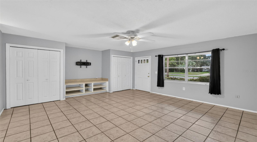 Light Filled Living Area With Neutral Paint And Tile Flooring