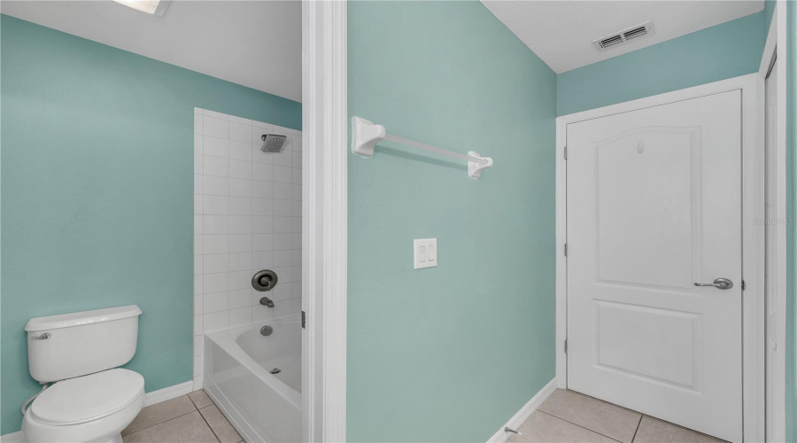 The Tub/Shower Combination And Toilet Are Thoughtfully Tucked Behind A Privacy Door, Creating A Functional Layout For Busy Mornings.