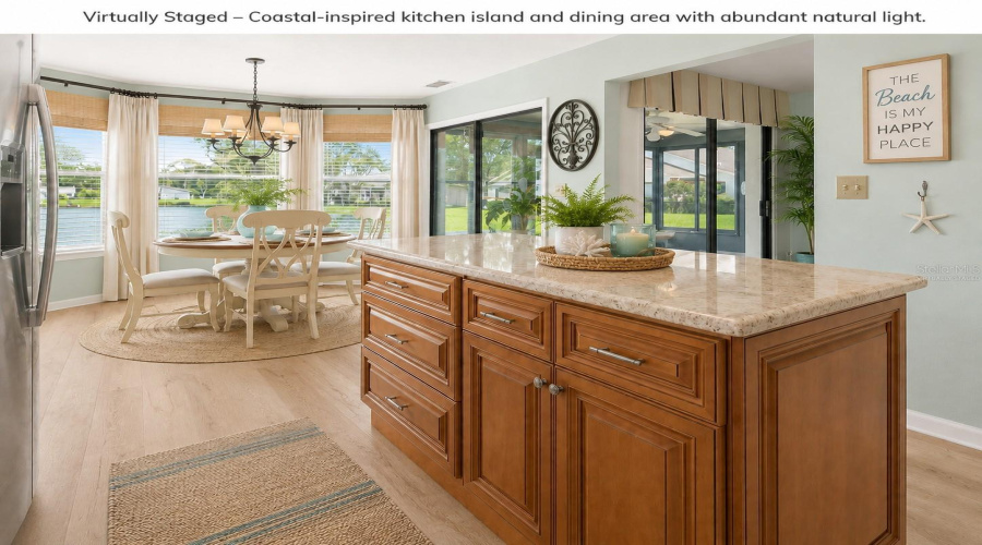 •  Kitchen: Virtually Staged – Coastal-Inspired Kitchen Featuring The Existing Cabinetry, Granite Countertops And Backsplash, With Added Décor And Refrigerator.