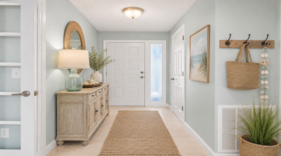 Foyer: Virtually Staged – Welcoming Foyer Enhanced With Light Coastal Décor, Creating A Bright And Inviting First Impression.