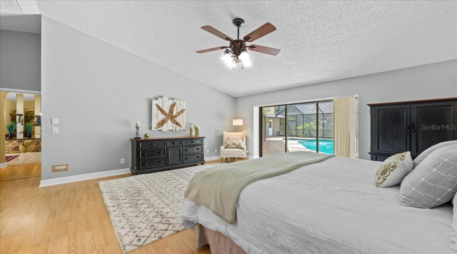 Primary Bedroom Featuring Vaulted Ceiling And Sliding Doors To The Pool