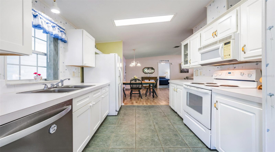 Galley Kitchen With Tile Floors And White Cabinets