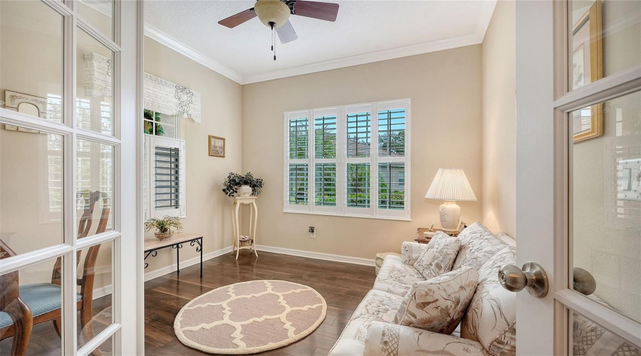 Versatile Den Behind Glass French Doors With Laminate Plank Flooring, And Plantation Shutters
