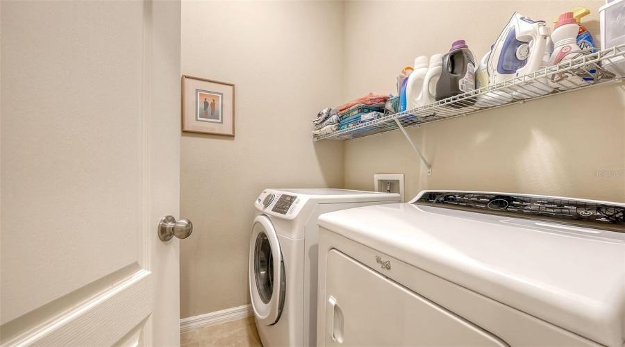 Interior Laundry Room With Samsung Front-Loading Washer And Whirlpool Dryer