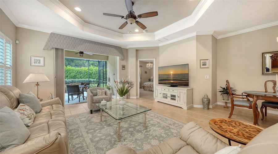 Spacious Great Room With Tray Ceiling, Recessed Lighting, And Plantation Shutters