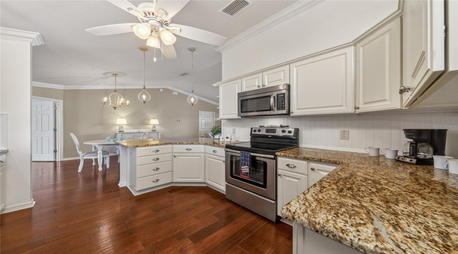 Kitchen Open To Dining And Living Areas With Granite Counters And Bar Seating