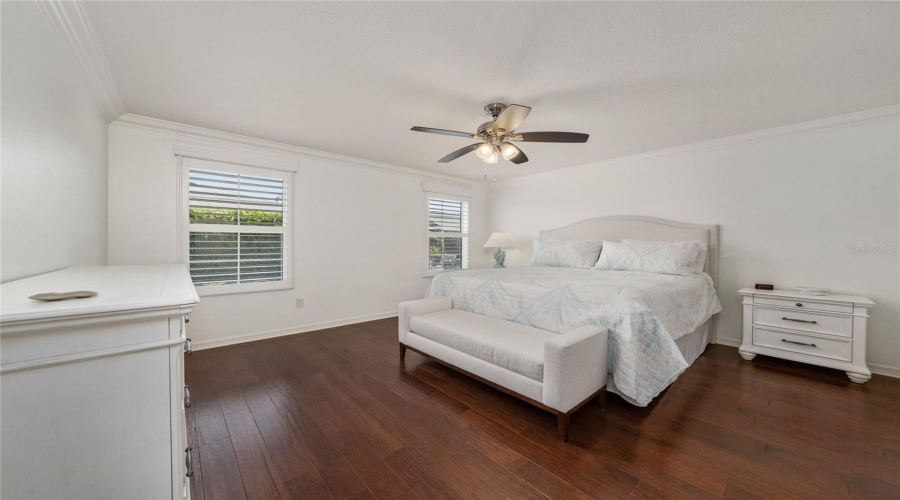 Primary Bedroom With King Bed Furnishings, Natural Light, And Plantation Shutters