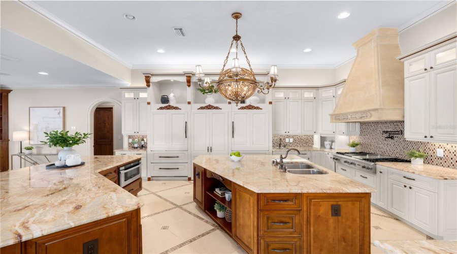 Designed For Grand-Scale Entertaining, The Expansive Chef'S Kitchen Pairs Dual Granite Islands With Richly Crafted Custom Cabinetry Throughout This Lake Mary, Fl Estate.