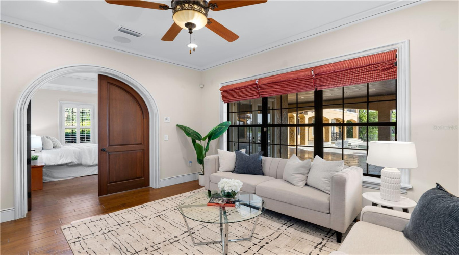 The First-Floor Primary Bedroom'S Inviting Sitting Room Offers Hardwood Flooring, A Graceful Arched Entry And Large Windows Overlooking The Estate'S Manicured Grounds.