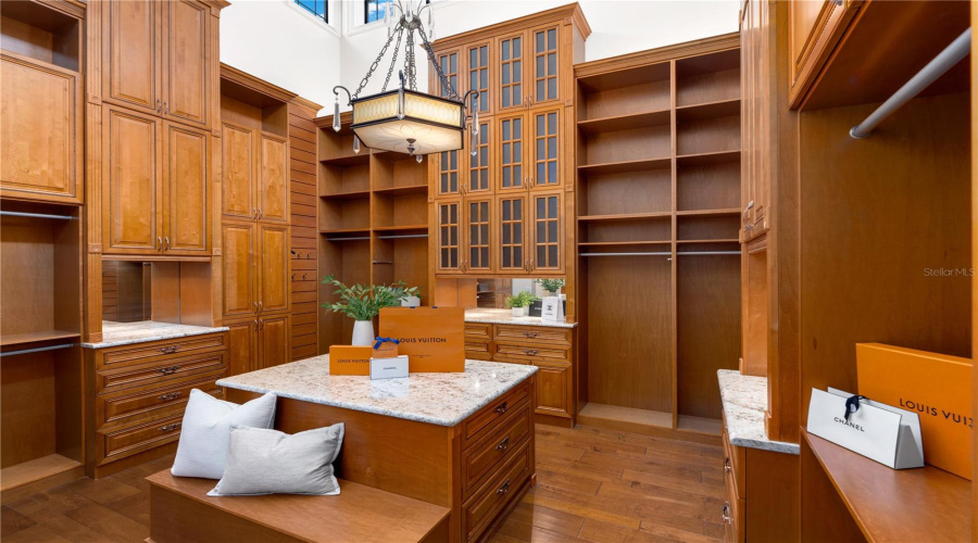 An Extraordinary Boutique-Inspired Dressing Room Showcases Floor-To-Ceiling Custom Wood Cabinetry, Extensive Wardrobe Storage And Elegant Glass-Front Displays For The Primary Bedroom.