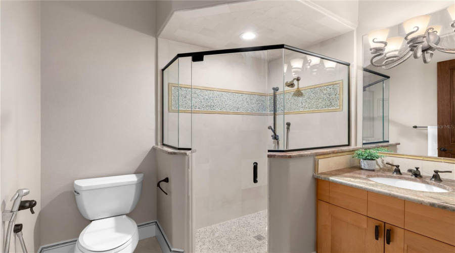 This Private En-Suite Bath Features A Glass-Enclosed Walk-In Shower, Custom Vanity And Beautifully Coordinated Stone And Tile Finishes.