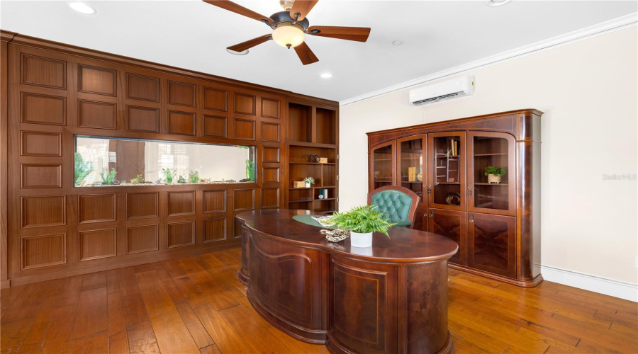 The Detached Executive Pavilion Features A Distinguished Private Office With Extensive Custom Wood Cabinetry, Built-In Workspace And Rich Hardwood Flooring — A Rare Amenity Among Lake Mary Luxury Estates.