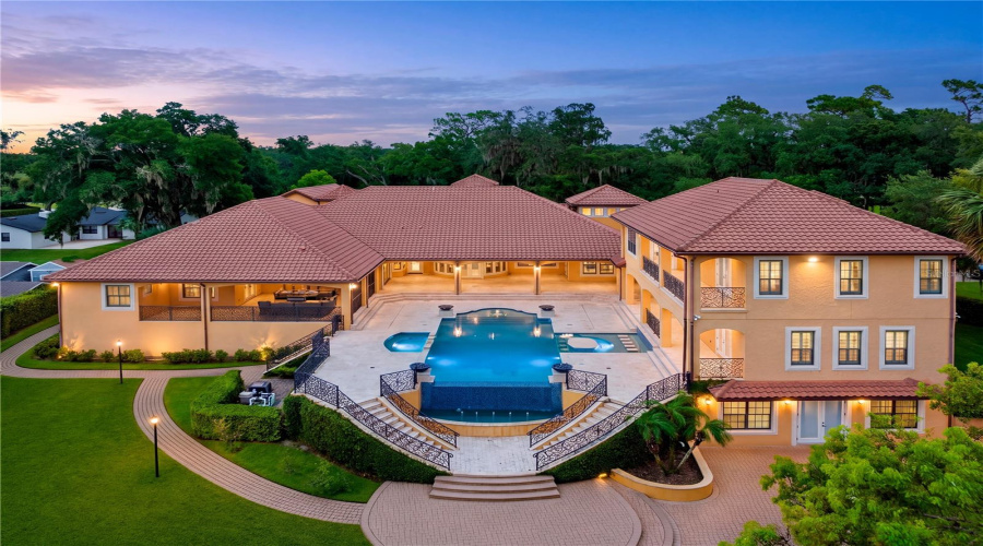 Breathtaking Twilight Perspective Of This Lake Mary, Fl Luxury Estate Captures The Resort-Inspired Setting, Infinity-Edge Pool And Striking Architecture Aglow At Dusk.