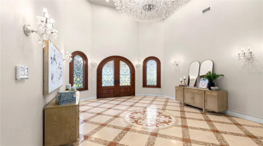 The Grand Foyer Reveals An Intricate Travertine Medallion, Arched Entry Doors, Crystal Lighting And Exquisite Architectural Detailing.
