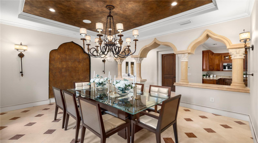 Graceful Arches And A Statement Chandelier Frame The Formal Dining Room, Showcasing This Lake Mary Estate'S Timeless Architectural Character And Attention To Detail.