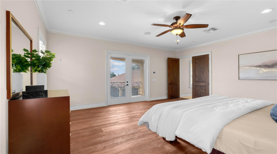 This Generously Proportioned Guest Residence Bedroom Combines Hardwood Flooring And A Tray Ceiling With Direct Access To The Covered Upper-Level Balcony.