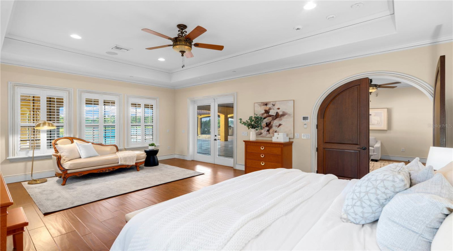 The Expansive Primary Bedroom Pairs Hardwood Flooring And A Private Sitting Area With Abundant Natural Light And Beautifully Scaled Proportions.