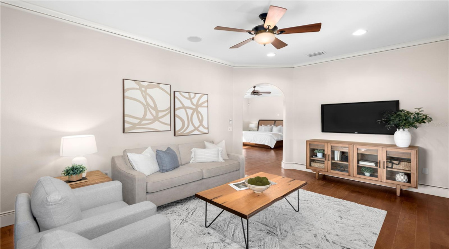A Sophisticated Private Sitting Area Leads Into The Second Primary Bedroom, With Hardwood Flooring And Custom Entertainment Cabinetry Offering Another Beautifully Appointed Space For Relaxation.