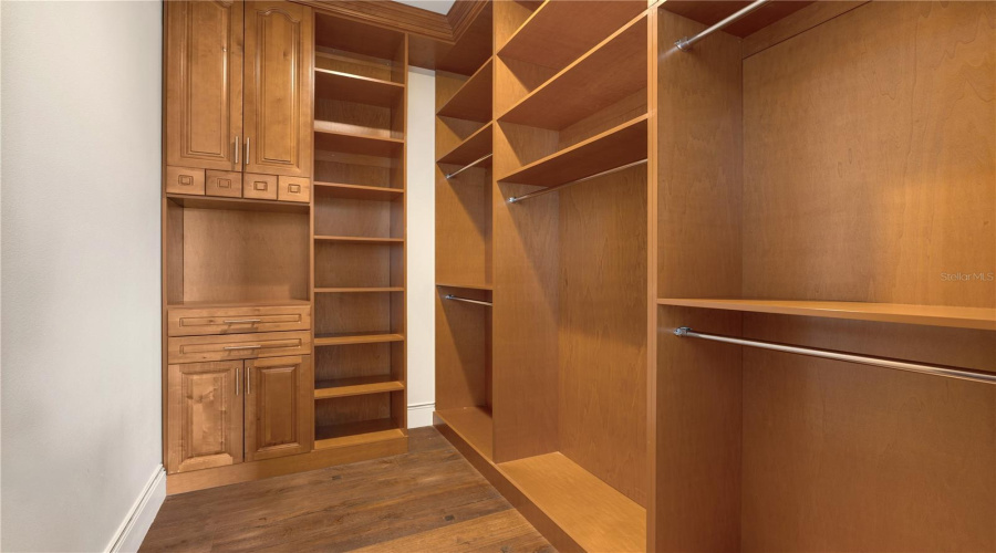 A Substantial Custom Walk-In Wardrobe Features Extensive Built-In Wood Cabinetry, Shelving And Multiple Hanging Areas For Exceptional Storage.