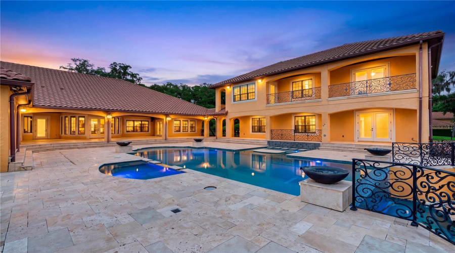A Resort-Inspired Pool And Spa Are Framed By Expansive Travertine Terraces, Graceful Architecture And Beautifully Illuminated Outdoor Living Spaces Overlooking Lake Mary.