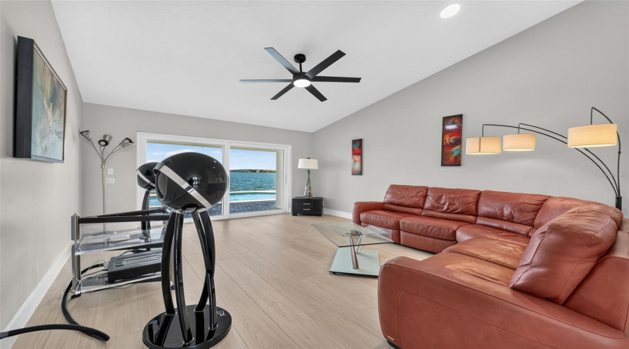 Elegant Formal Living Room Featuring Sliding Glass Doors That Frame Serene Water Views And Fill The Space With Natural Light.