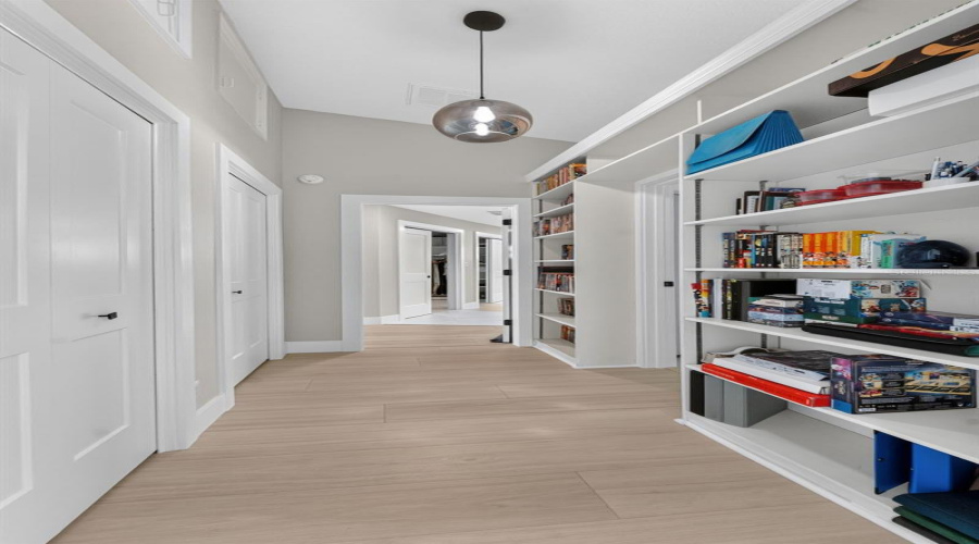 Hallway Featuring Built-In Shelving And Extra Closet Space, Leading To Bedroom 2 And The Luxurious Primary Suite