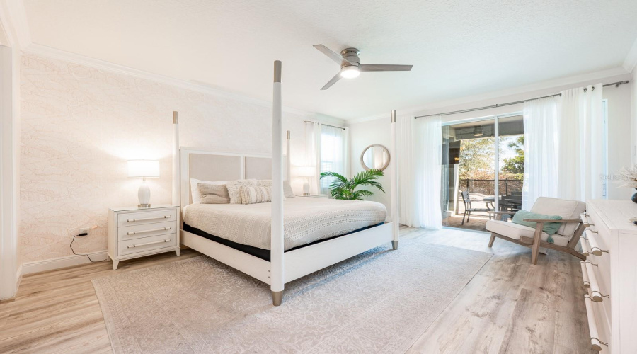 The Main-Level Primary Suite Is A Serene Escape, Showcasing Luxury Vinyl Plank Flooring, Private Sliding Doors To The Pool Area, And A Spa-Inspired En Suite Bath.