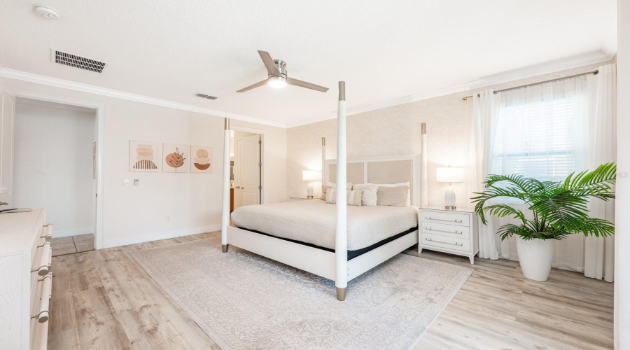 The Main-Level Primary Suite Is A Serene Escape, Showcasing Luxury Vinyl Plank Flooring, Private Sliding Doors To The Pool Area, And A Spa-Inspired En Suite Bath.
