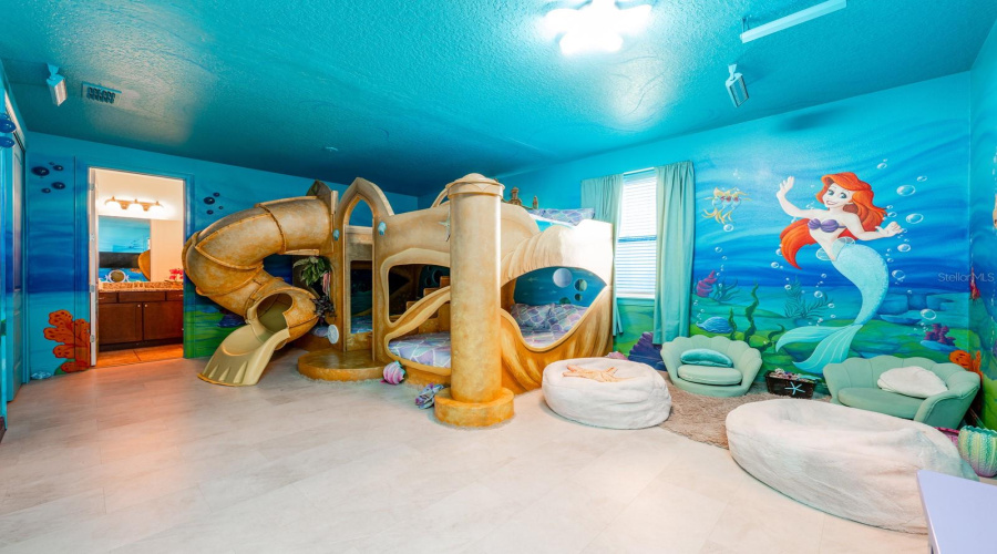 Dive Under The Sea With Ariel In A Stunning Ocean-Inspired Room Featuring Hand-Painted Murals, Coral Accents, And A Whimsical Sandcastle Bed.
