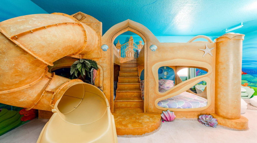 Dive Under The Sea With Ariel In A Stunning Ocean-Inspired Room Featuring Hand-Painted Murals, Coral Accents, And A Whimsical Sandcastle Bed.