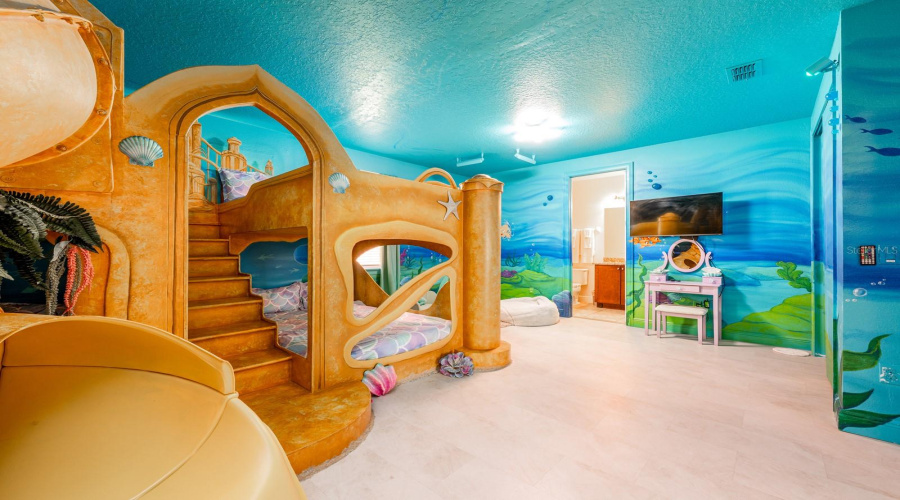 Dive Under The Sea With Ariel In A Stunning Ocean-Inspired Room Featuring Hand-Painted Murals, Coral Accents, And A Whimsical Sandcastle Bed.