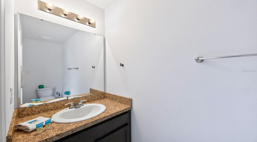 A Convenient Half Bath Is Located Just Off The Pool Area, Perfect For Guests.