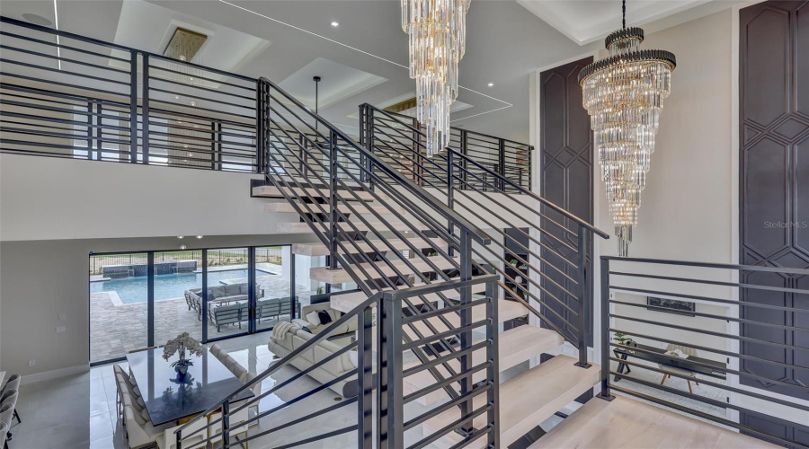 Architectural Floating Staircase Creates A Dramatic Focal Point Between Both Levels