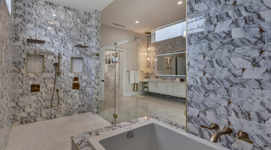 Luxurious Soaking Tub Incorporated Within The Expansive Primary Wet Room With Accompanying Built In Seat