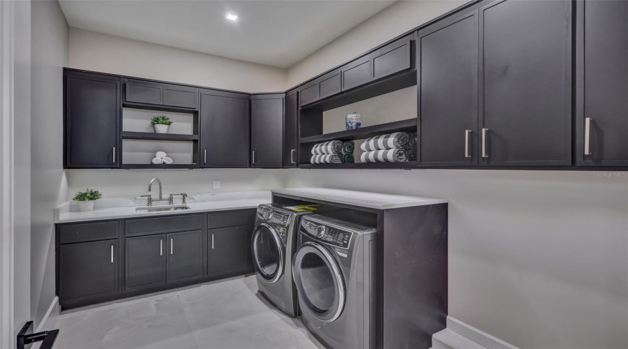 Large Dedicated Laundry Room With Extensive Cabinetry, Undermount Lighting And Workspace