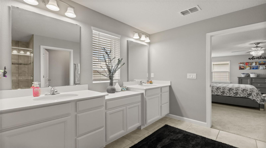 Primary Bath Features Dual Vanities With Solid-Surface Tops.