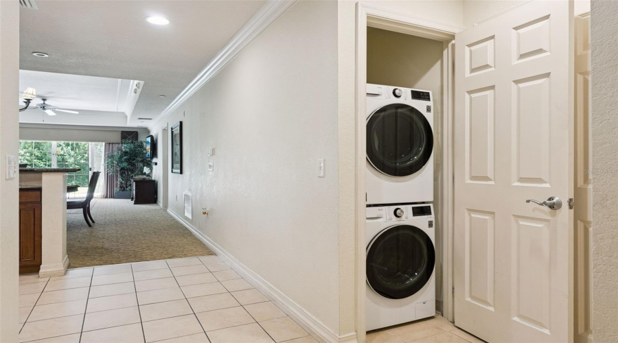 Laundry Closet: Dedicated Hallway Laundry Closet Equipped With A Modern Stacked Washer And Dryer Set.