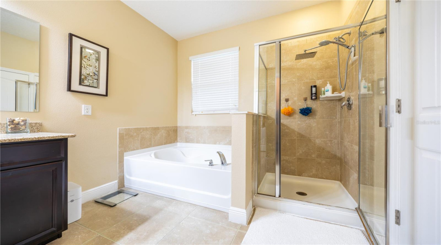 Primary Bathroom With Soaking Tub, Separate Glass Shower And Granite Vanity