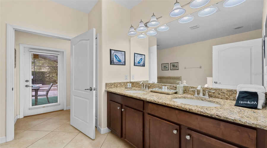 Spacious Primary Bathroom With Granite Double Vanity And Generous Counter Space