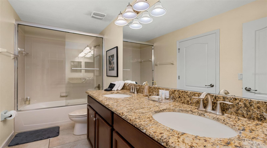 Additional View Of The Primary Bathroom With Granite Countertops And Double Vanity